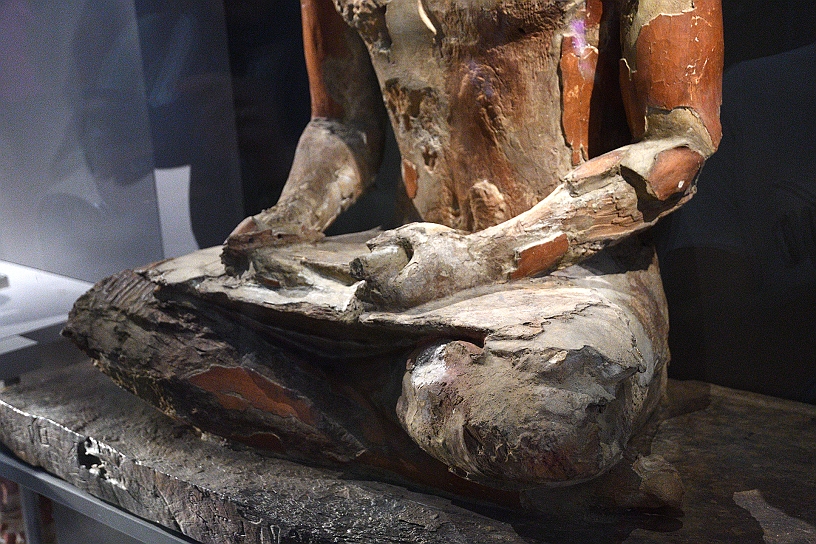 32 MAK_7076.jpg - La posa è quella tipica degli scribi, con le gambe incrociate ed un rotolo di papiro aperto sulle ginocchia, mentre tiene una penna nella mano destra.